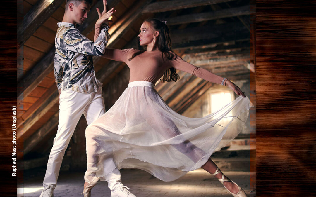 Two dancers in the attic in a dramatic pose emphasizing fully engaged partnership